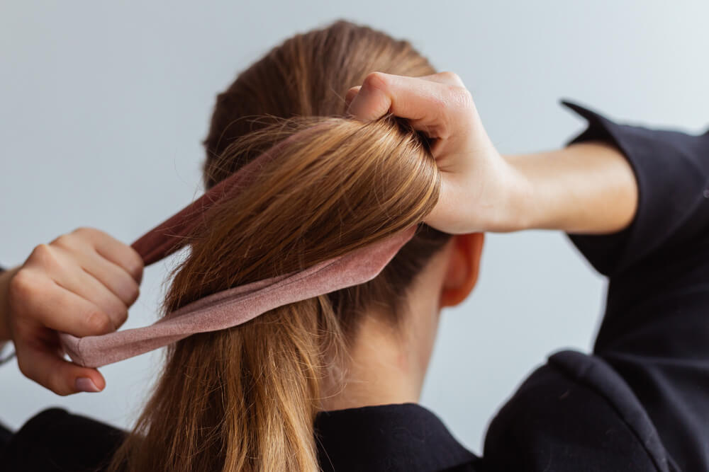 Woman tying hair up