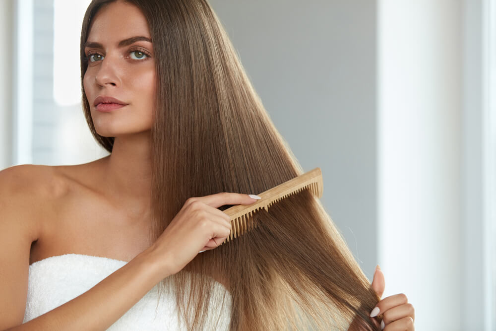 Woman using comb to care for extensions