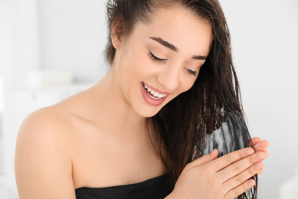 Woman using Nubi shampoo and conditioner