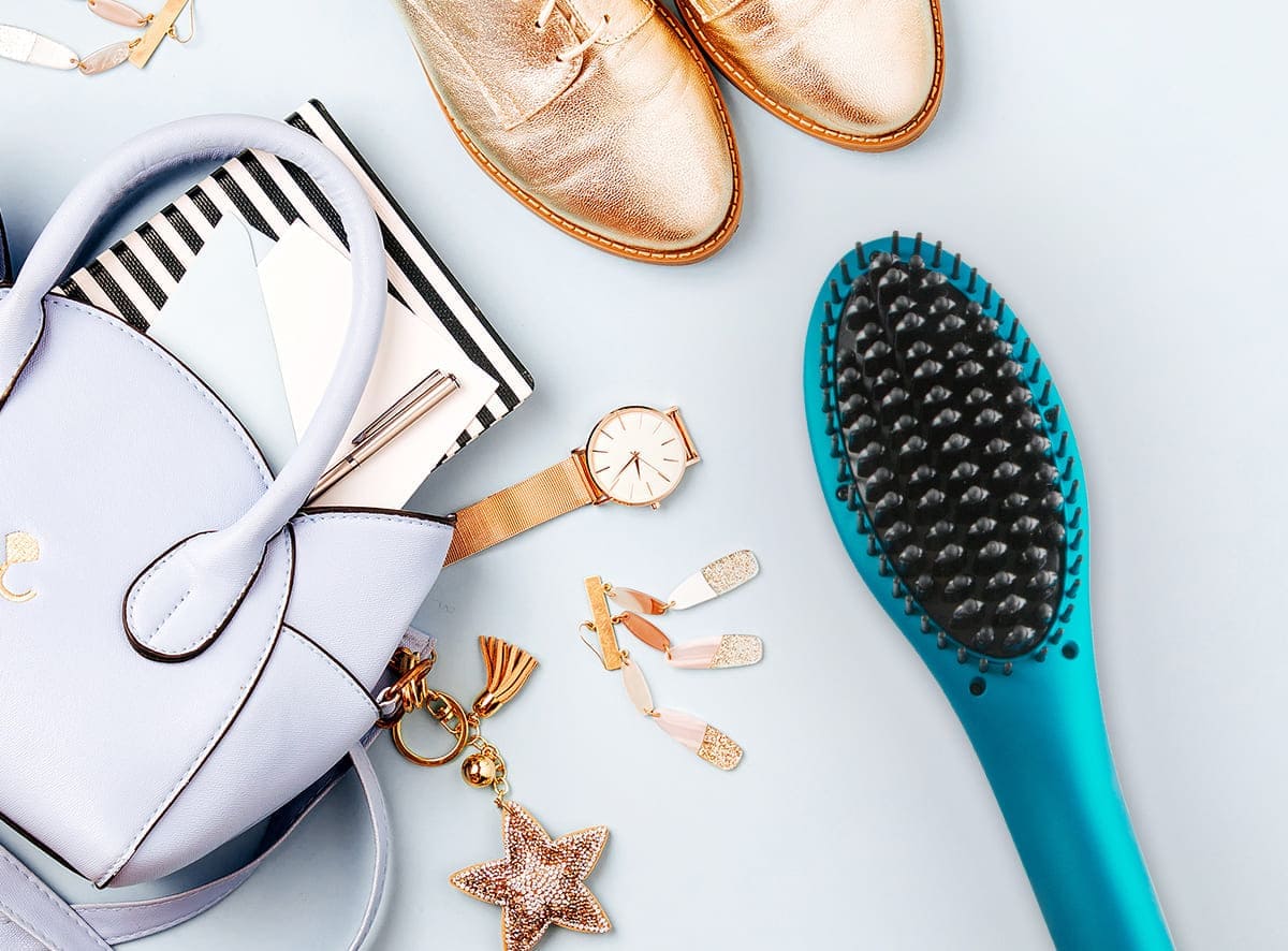 Nubi Simply Sleek Brush next to handbag and accessories