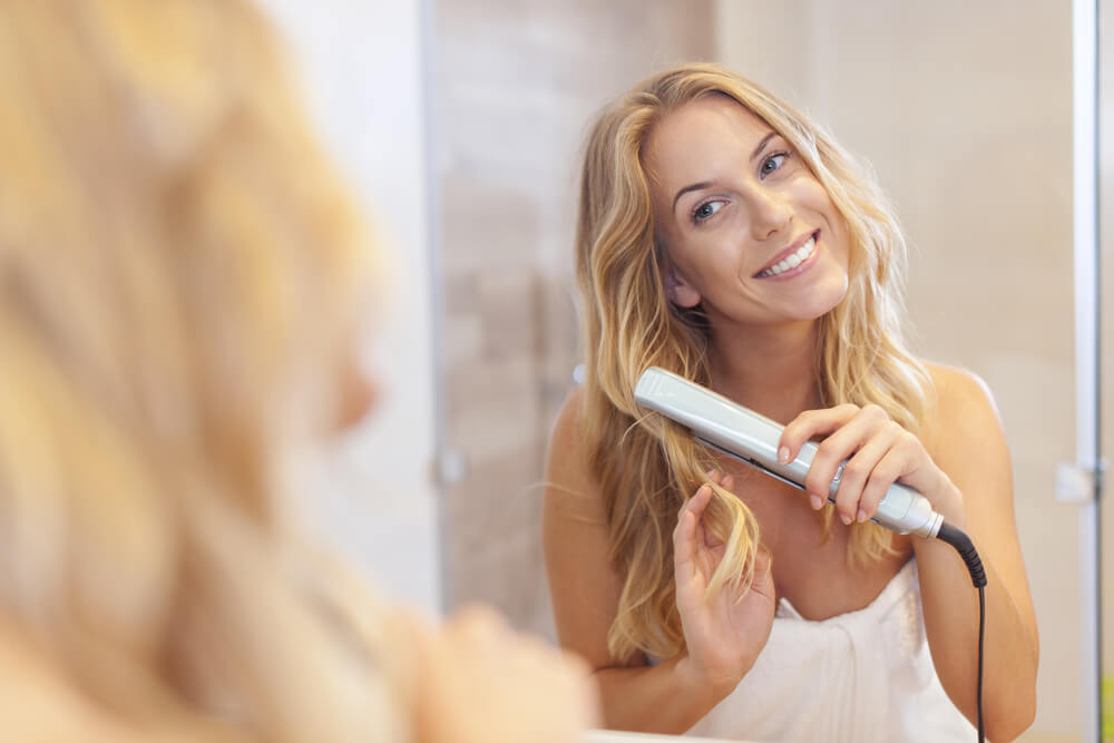 Woman using flat iron as both a hair curler & straightener