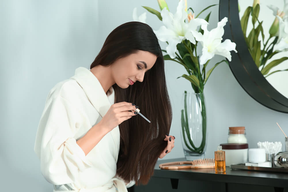 Woman applying hair serum
