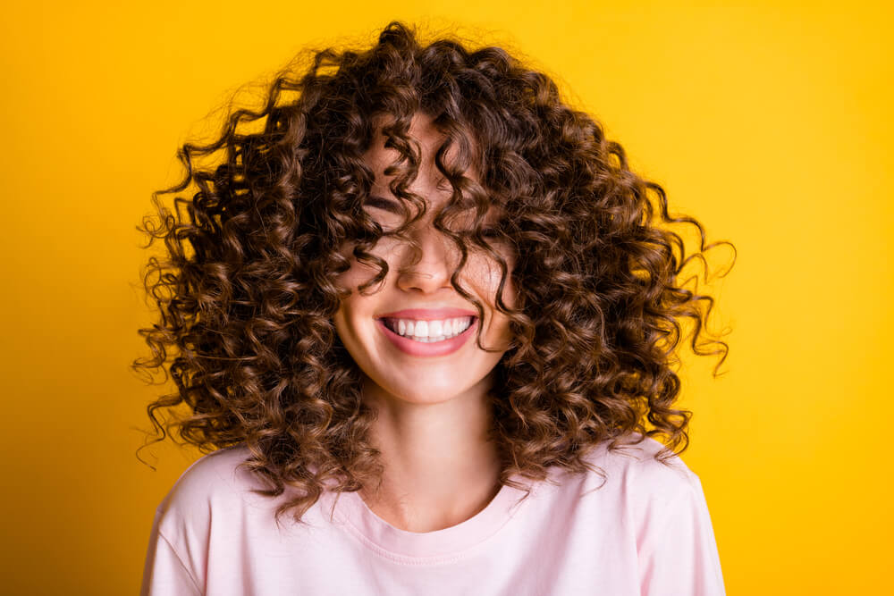 woman curly hair smiling